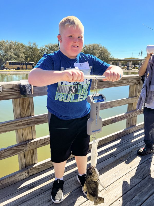 A child weighs a fish he caught at the Special Olympics fishing tournament