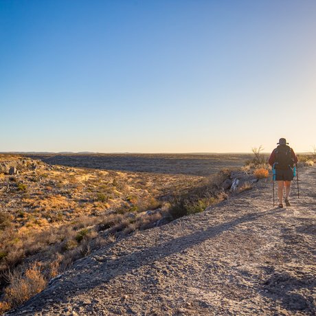 A woman hikes the Canyon Rim trail at Seminole Canyon state park