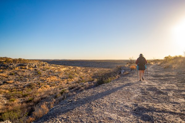 A woman hikes the Canyon Rim trail at Seminole Canyon state park