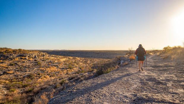 A woman hikes the Canyon Rim trail at Seminole Canyon state park