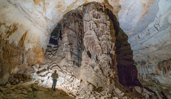 An explorer looks up from inside Kickapoo Cavern