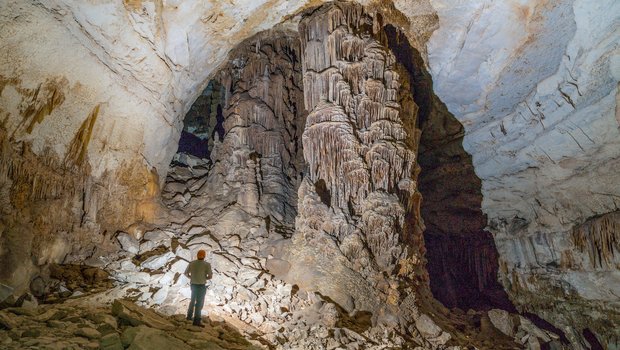 An explorer looks up from inside Kickapoo Cavern