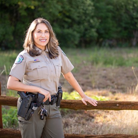 Joann Garza-Mayberry stands alongside a fence