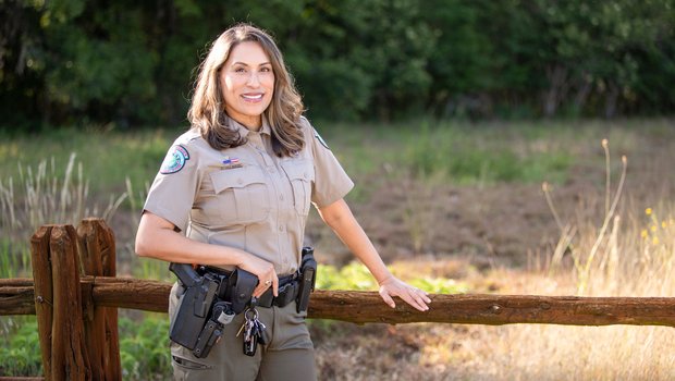 Joann Garza-Mayberry stands alongside a fence