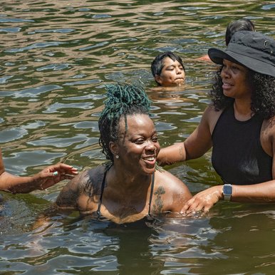 A group of African American women swim in a Texas river