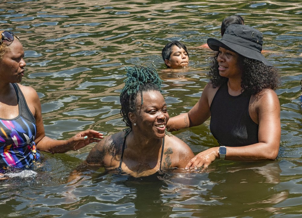 A group of African American women swim in a Texas river