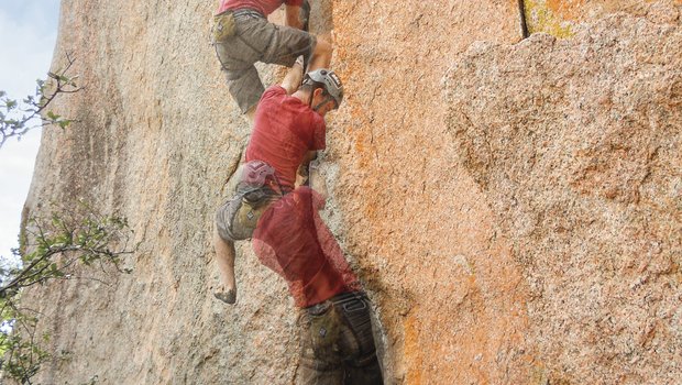 A multi-stage photograph showing the ascent of a climber working his way up a large rock face
