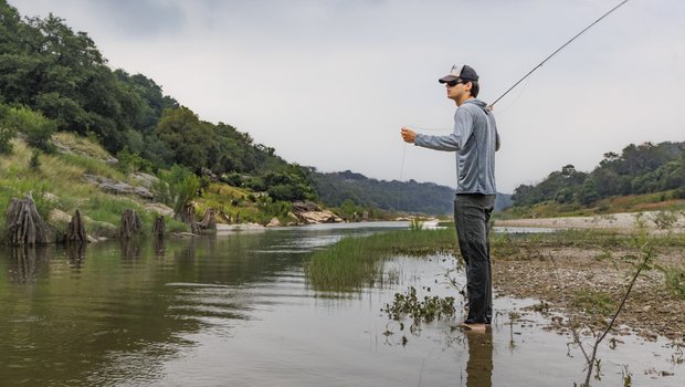 Americana singer/songwriter Calder Allen prepares to cast his fly rod along the river