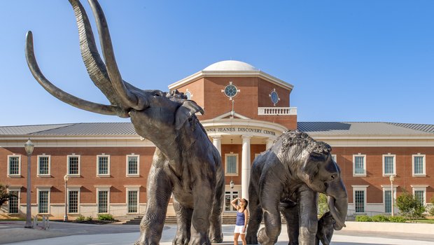 Two large bronze sculptures of mammoths stand outside the Mayborn Museum in Waco, Texas.