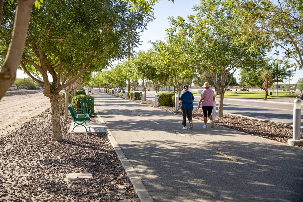 Two woman walking on shaded paved Paso del Norte trail in El Paso