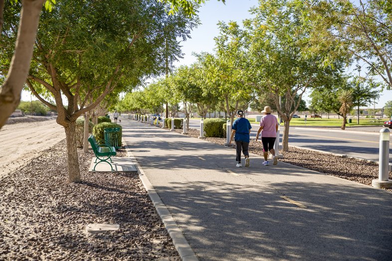 Two woman walking on shaded paved Paso del Norte trail in El Paso