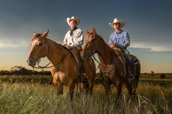Two cowboys on horses in a prairie