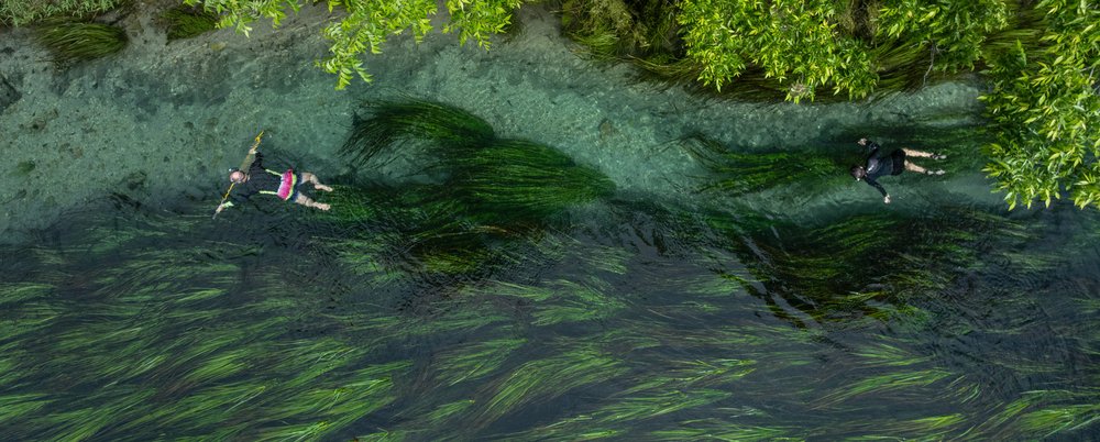 People floating in the San Marcos River for spearfishing.