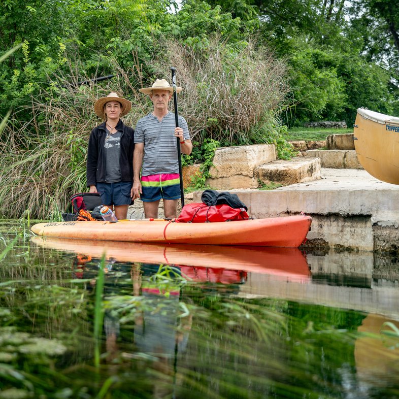 Ryan Gossen and wife Laura stand in water next to a Kayak ready to go Spearfishing.