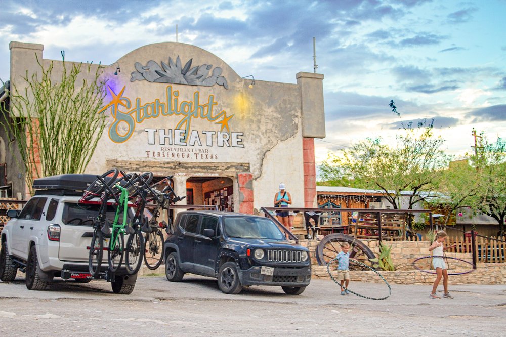 Starlight Theatre in Terlingua with cars and children hula hooping.