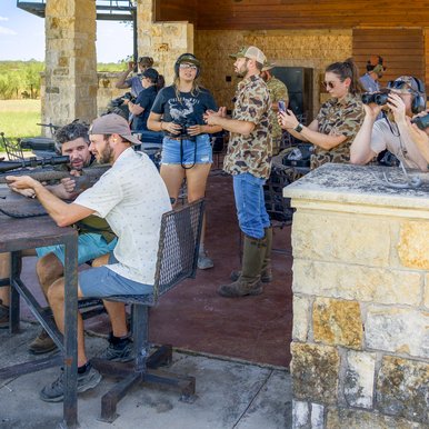 A group of hunters receive instruction on spotting deer and sighting in rifles