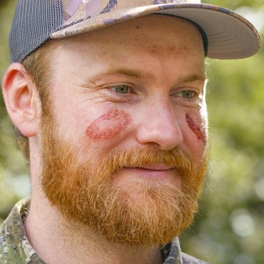 Hunter Eric Robbins' cheeks are marked with blood from his first deer harvest