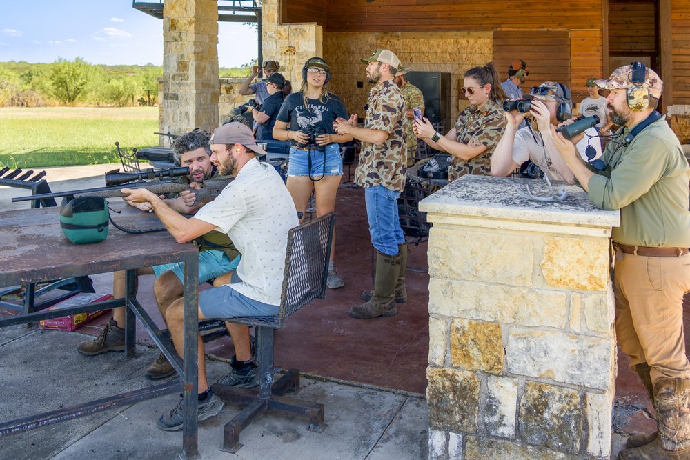 A group of hunters receive instruction on spotting deer and sighting in rifles