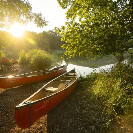 Two empty red canoes stand along the river shore at Devils River state natural area