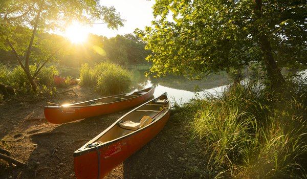 Two empty red canoes stand along the river shore at Devils River state natural area