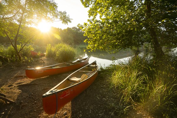 Two empty red canoes stand along the river shore at Devils River state natural area