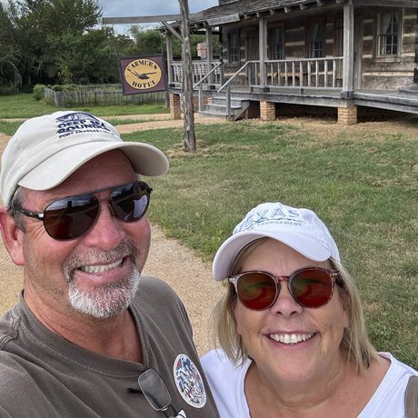 Great Outdoor Scavenger Hunt participants Cyndi and Jimmy Morris pose outside a log building