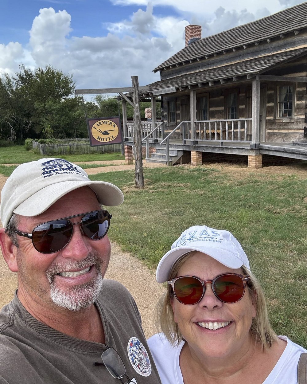 Great Outdoor Scavenger Hunt participants Cyndi and Jimmy Morris pose outside a log building