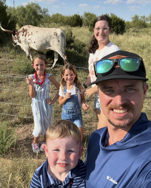 Great Outdoor Scavenger Hunt participants the Tipps family pose with a Longhorn in the background