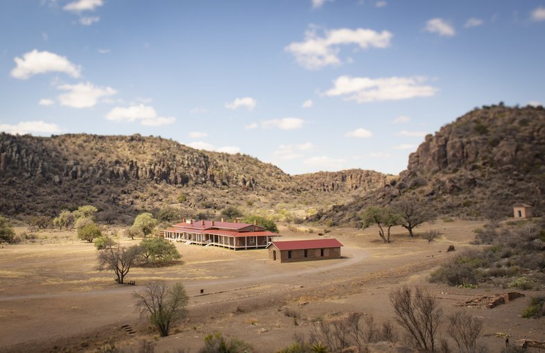Two building at Fort Davis  in front of hills.
