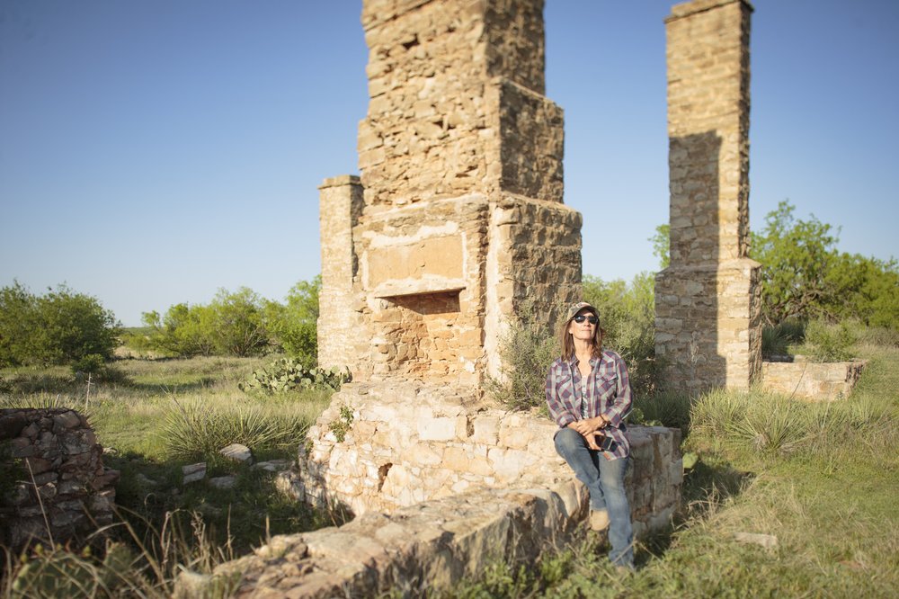 Woman leaning on a chimney at Fort Phantom Hill.