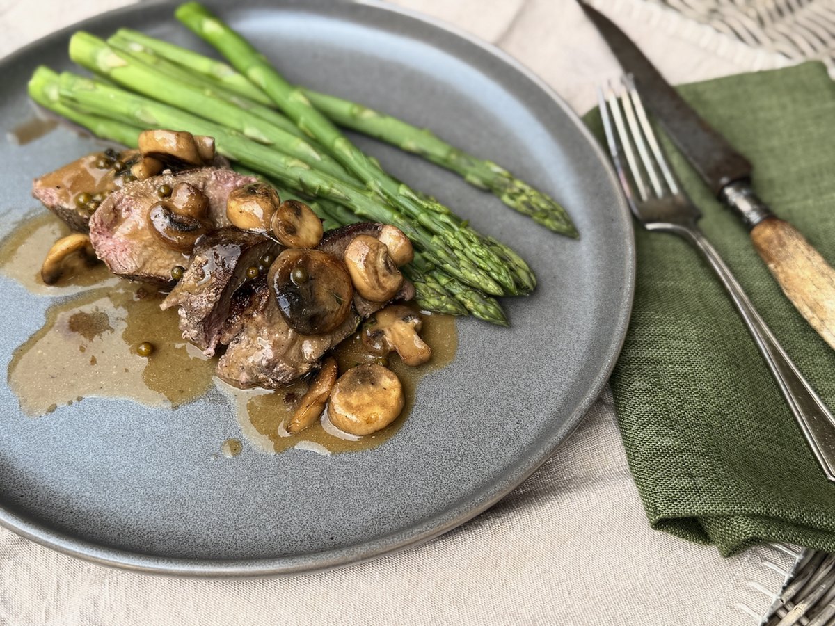 A plate of seared blackstrap with mushrooms and asparagus.