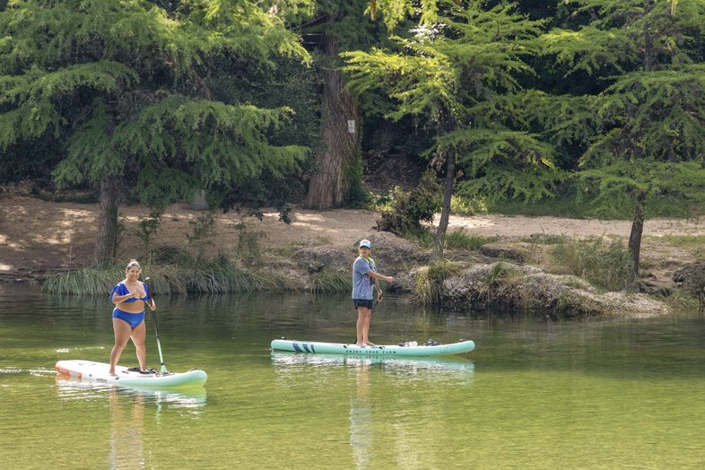 Two people on paddleboat in the Frio River at Garner State Park.