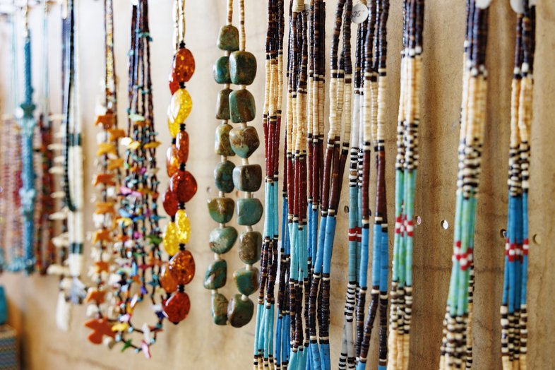 Beaded necklaces hanging on a wall.