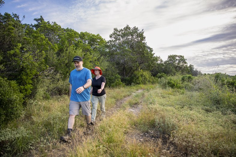 A couple hikes along a trail at Government Canyon State Natural Area