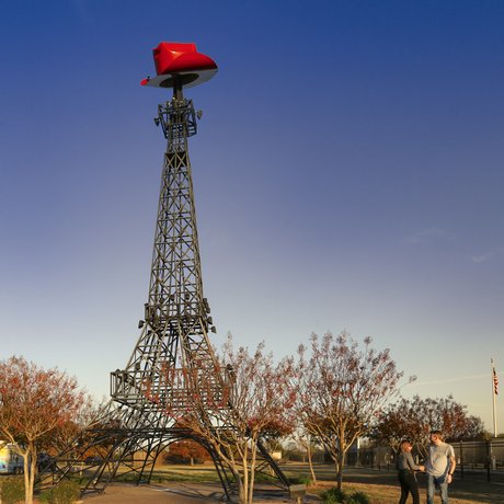 A replica of the Eiffel Tower with a red cowboy hat on top