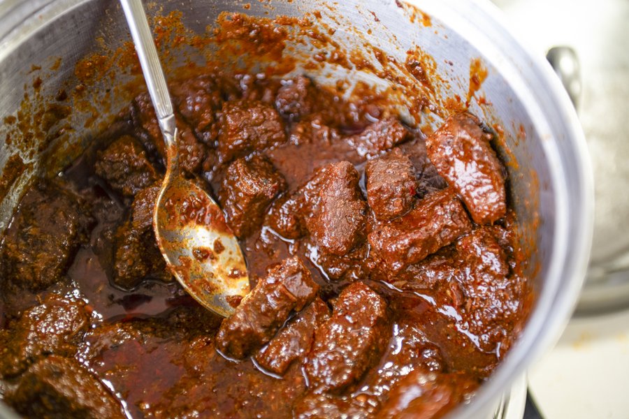 Aoudad red chili in a pot with a spoon.