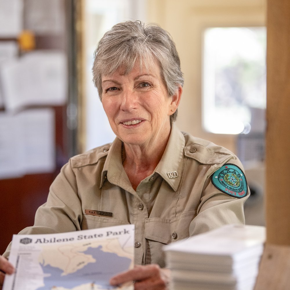 Kay O'dell holding a map of Abilene State Park.