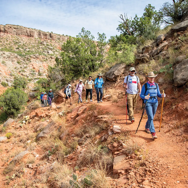 a group hiking on a trail in Palo Duro Canon