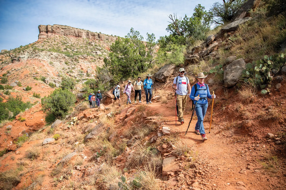 a group hiking on a trail in Palo Duro Canon