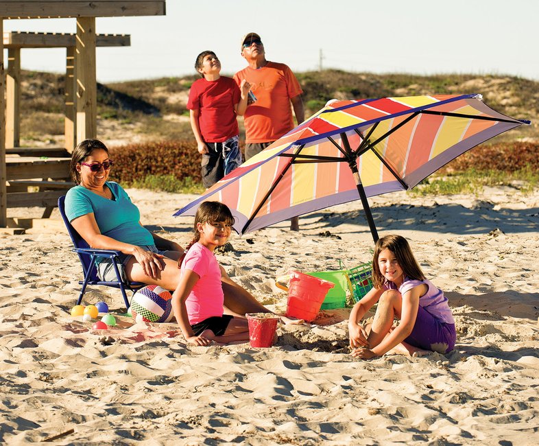 A family on the beach with a sun umbrella