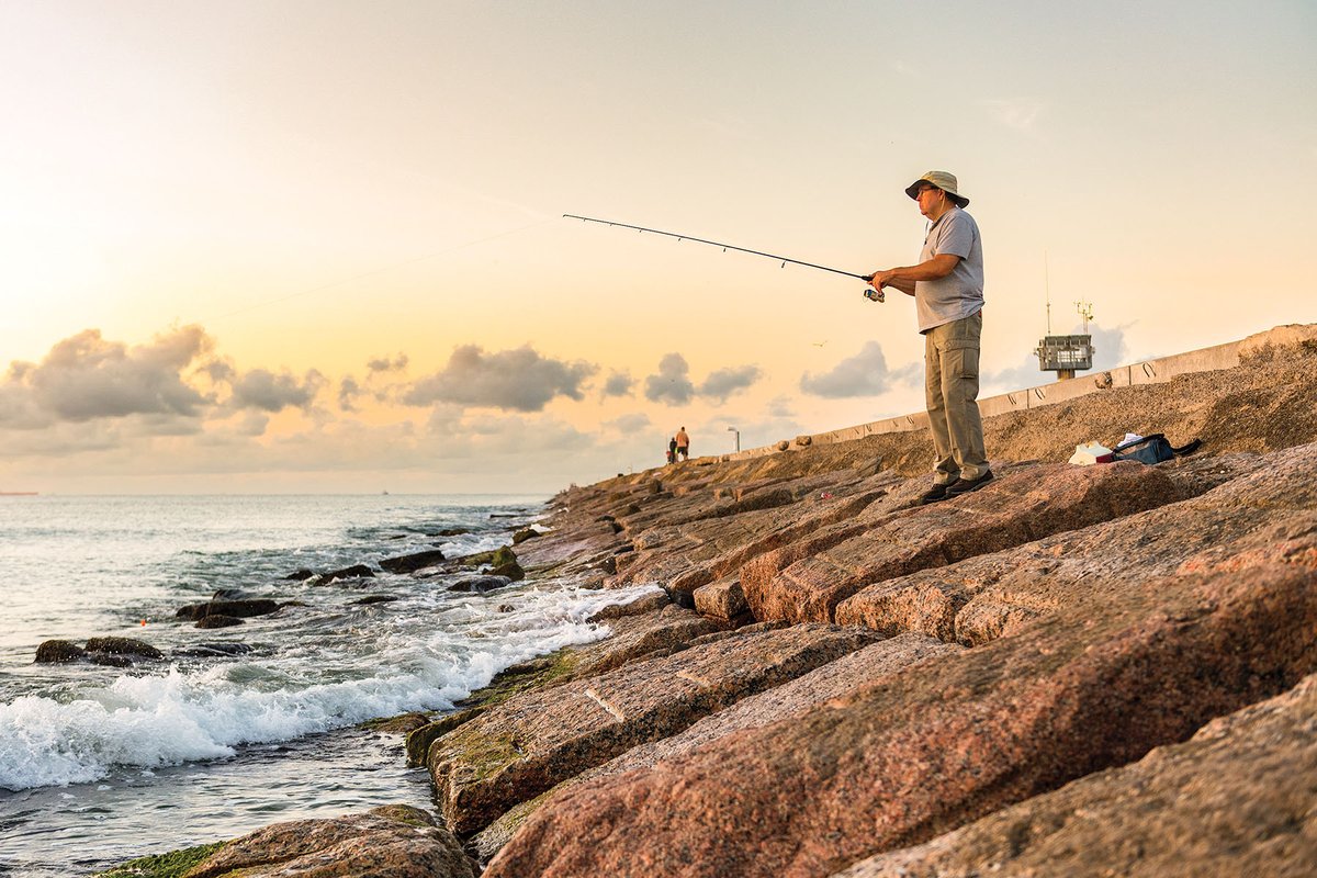 A man fishing from a jetty.