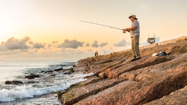 A man fishing from a jetty.