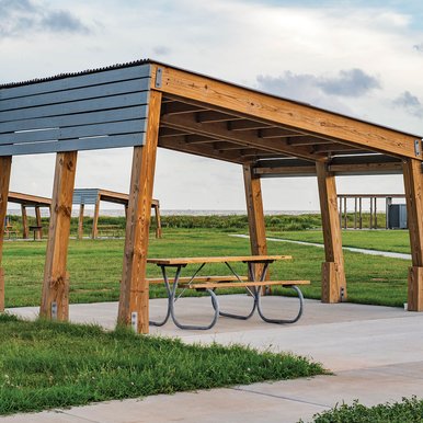 A picnic table with a flat rectangula structre above.