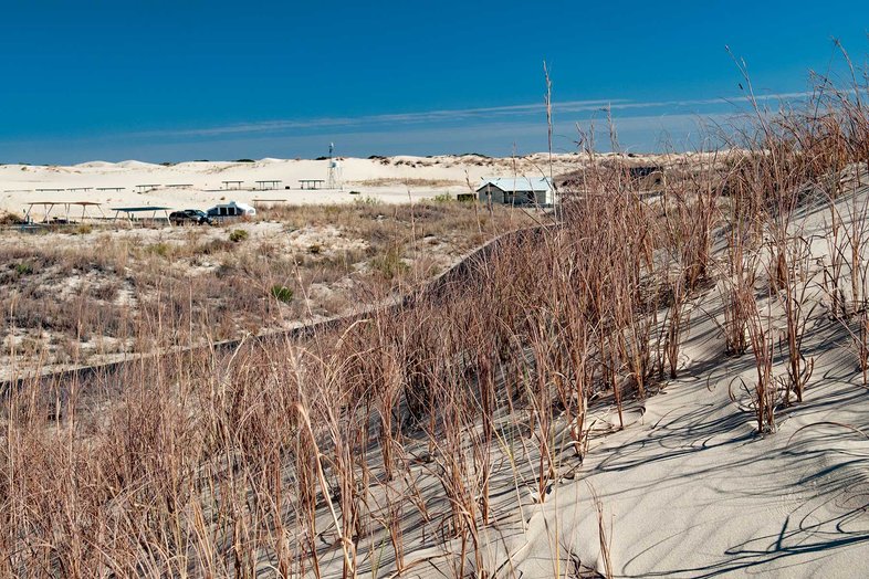 A road surrounded by sandhills.