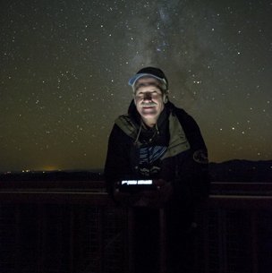 Bill Wren at McDonald Observatory with a starry night sky