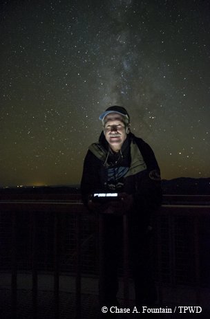 Bill Wren at McDonald Observatory with a starry night sky