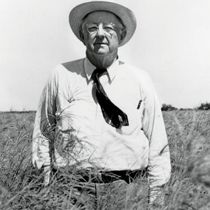 Caesar Kleberg standing in a grassy field wearing a cowboy hat