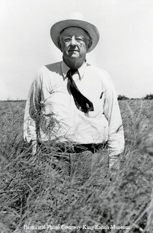 Caesar Kleberg standing in a grassy field wearing a cowboy hat