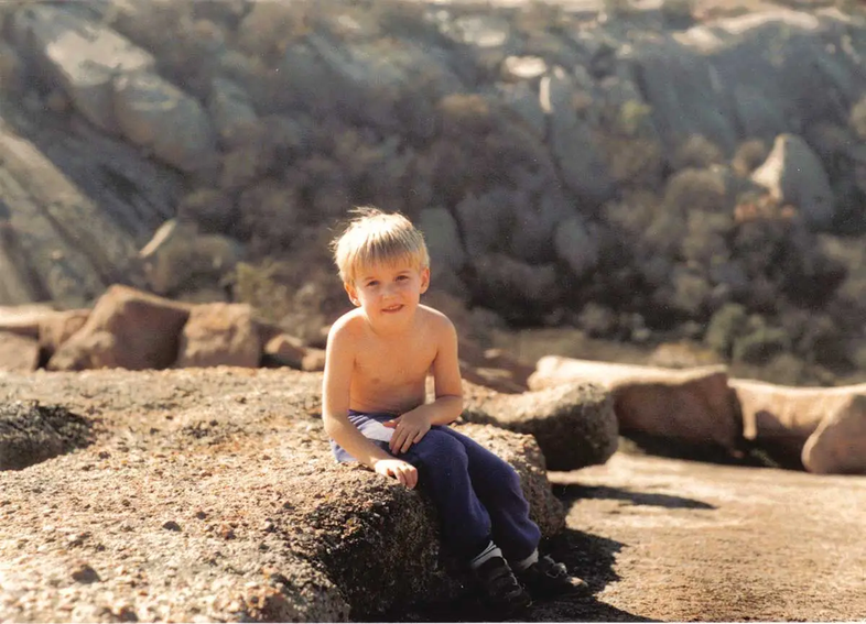 Four year old Chet Garner at EnchantedRock sitting on a rock formation