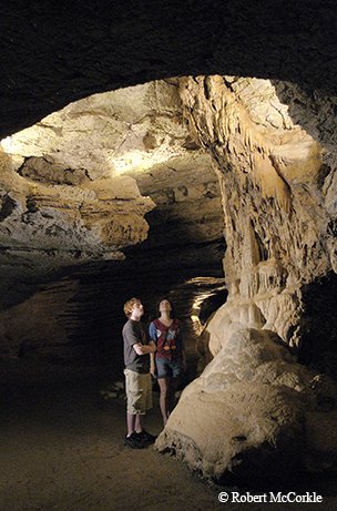 Children looking up through a hole in Longhorn Cavern